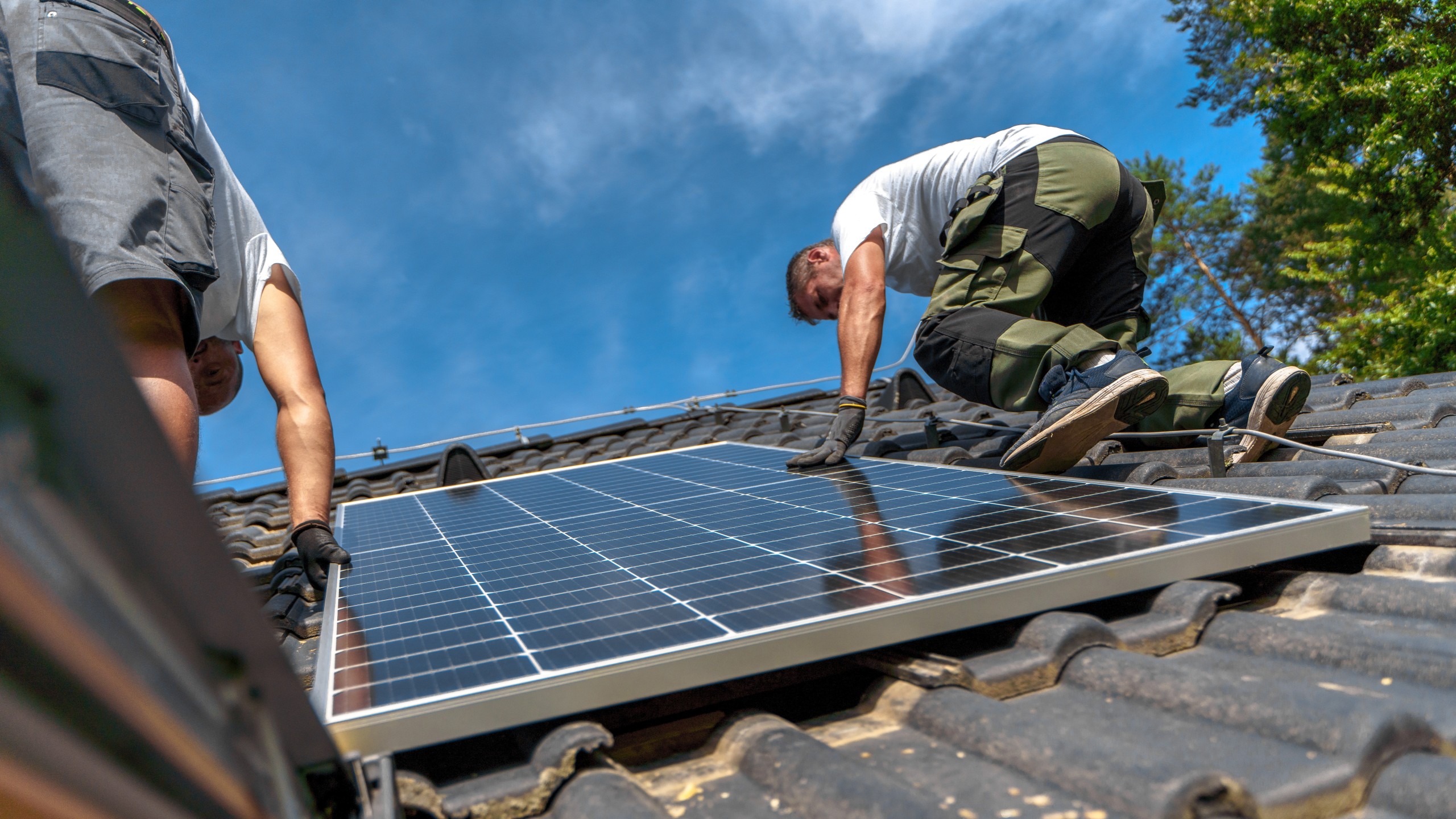 Dachdecker montieren eine Solaranlage.